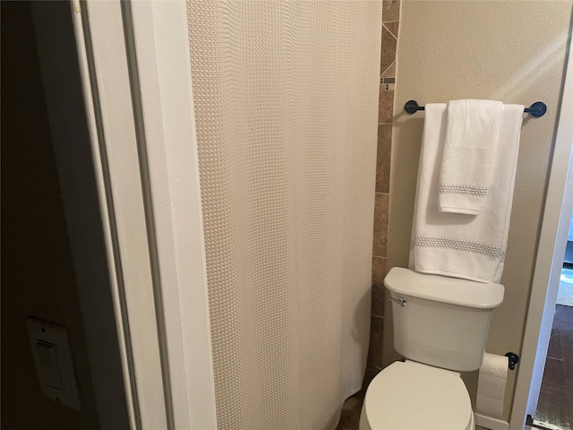 bathroom with curtained shower and toilet