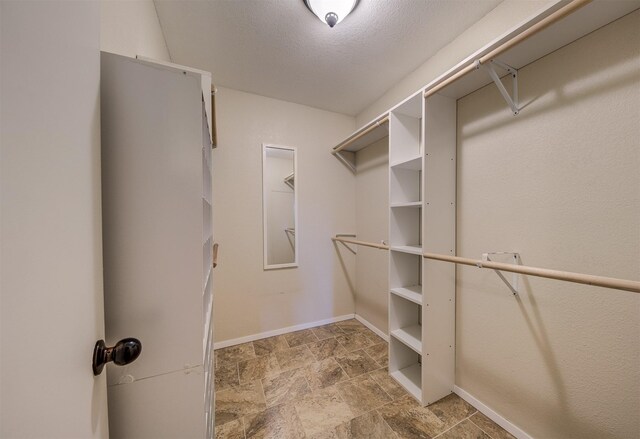 spare room featuring a textured ceiling, dark hardwood / wood-style flooring, ceiling fan, and a healthy amount of sunlight