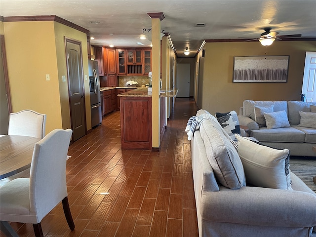 living room featuring ceiling fan, crown molding, and dark hardwood / wood-style floors