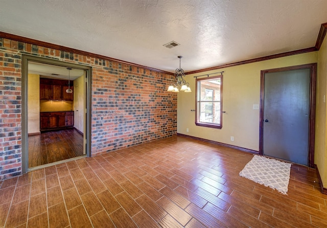 unfurnished dining area featuring brick wall, a notable chandelier, visible vents, baseboards, and a textured ceiling