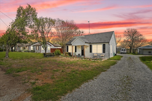 single story home with an outdoor structure, a lawn, and a garage