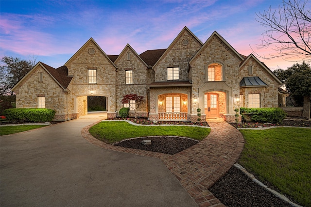 french provincial home with french doors and a lawn