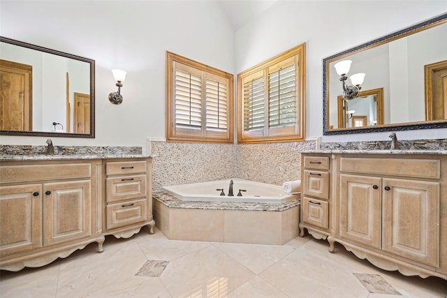 bathroom with a relaxing tiled tub, vanity, and vaulted ceiling