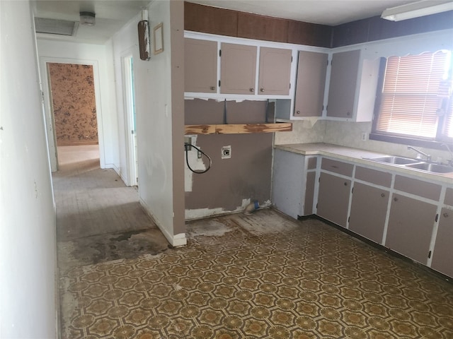 kitchen featuring backsplash, dark tile flooring, sink, and gray cabinetry