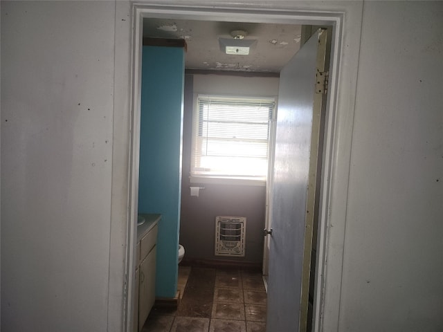 hallway featuring dark tile flooring