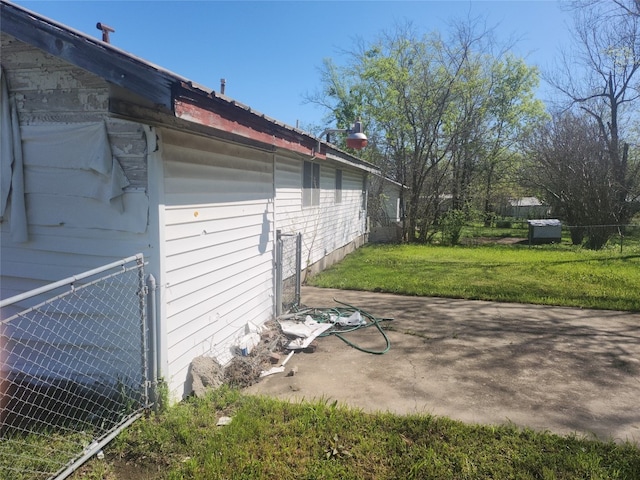 view of side of property with a patio and a yard