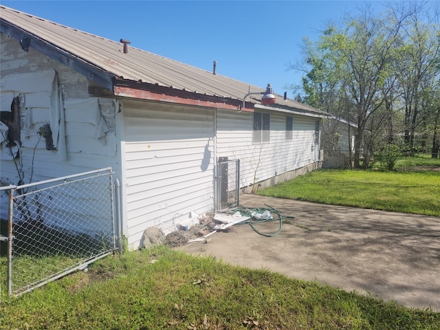 view of side of home featuring a lawn and a patio