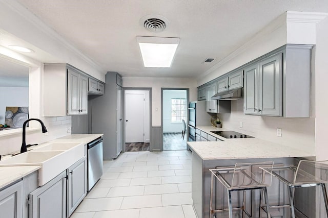 kitchen with kitchen peninsula, light tile floors, stainless steel dishwasher, light stone counters, and crown molding