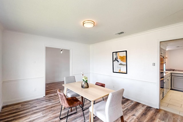 dining area with dark tile flooring and crown molding