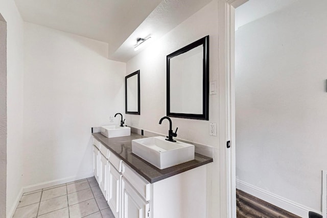 bathroom with oversized vanity, tile flooring, and dual sinks