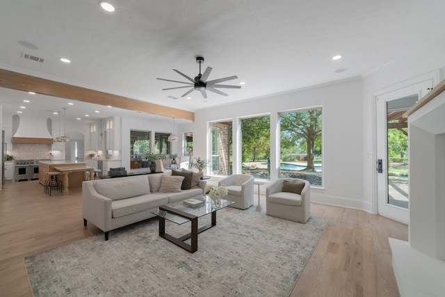 living room with crown molding, light hardwood / wood-style floors, and ceiling fan