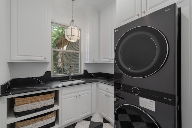 washroom featuring cabinets, stacked washer / dryer, sink, and light tile patterned floors