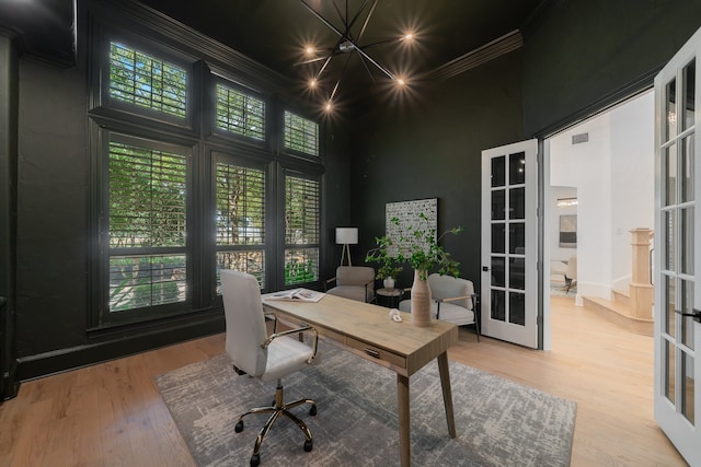 home office featuring french doors, crown molding, wood-type flooring, and a high ceiling