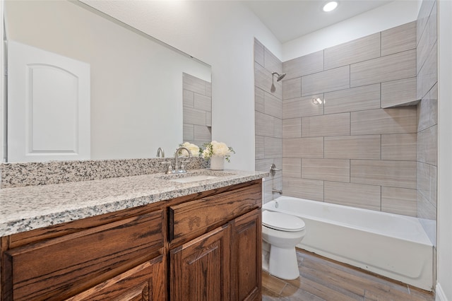 full bathroom featuring vanity, toilet, hardwood / wood-style flooring, and tiled shower / bath combo