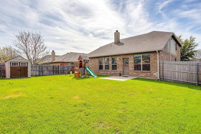 back of property with a patio, a storage unit, a yard, and a playground