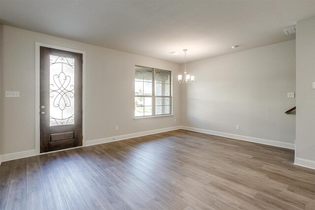 foyer entrance featuring ceiling fan with notable chandelier and light hardwood / wood-style floors