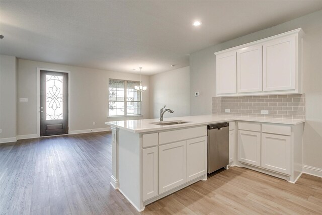 kitchen with sink, white cabinets, light hardwood / wood-style floors, kitchen peninsula, and stainless steel appliances