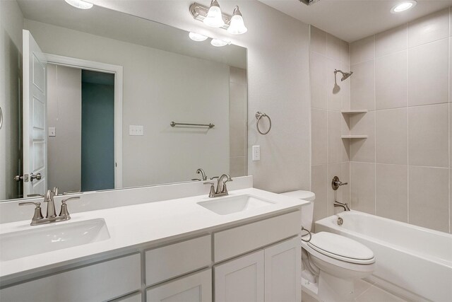 full bathroom with tiled shower / bath combo, vanity, tile patterned floors, and toilet