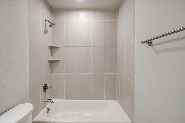 full bathroom with vanity, tiled shower / bath, and toilet