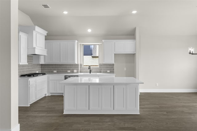 kitchen with white cabinets, sink, dark hardwood / wood-style floors, appliances with stainless steel finishes, and a kitchen island