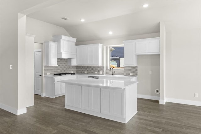 kitchen with a center island, white cabinetry, vaulted ceiling, and stainless steel gas stovetop