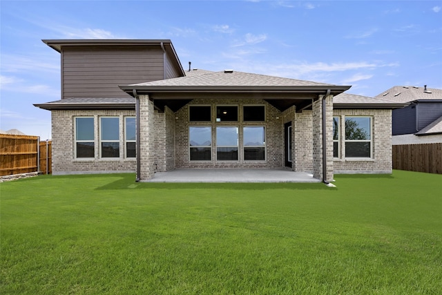 rear view of house featuring a yard and a patio