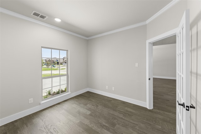 empty room with crown molding, plenty of natural light, and dark wood-type flooring