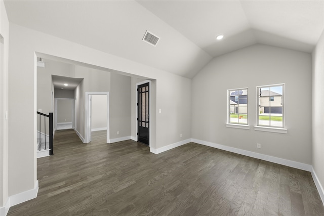 empty room with dark hardwood / wood-style flooring and vaulted ceiling