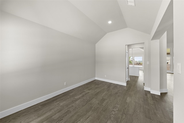 additional living space with dark hardwood / wood-style flooring and vaulted ceiling