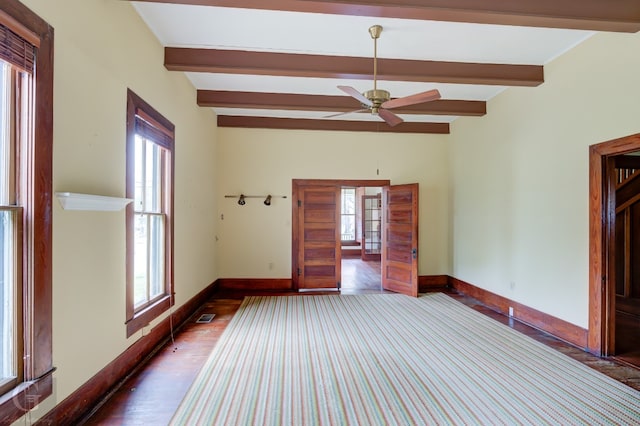 empty room with beam ceiling, dark hardwood / wood-style floors, and ceiling fan