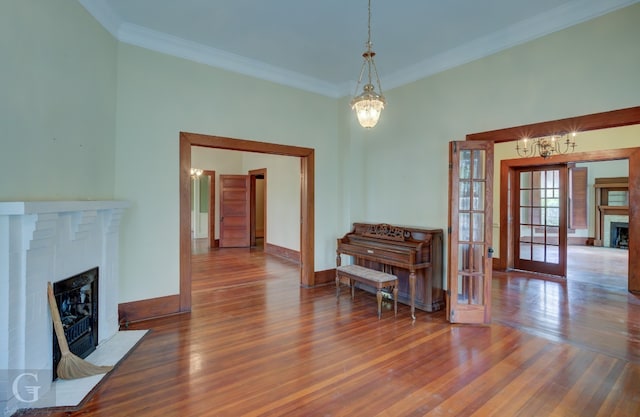 interior space with dark hardwood / wood-style flooring, a notable chandelier, crown molding, and french doors