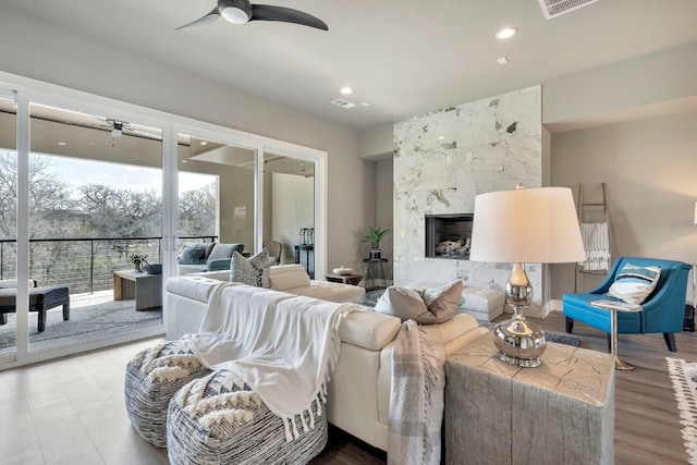 living room featuring ceiling fan and a fireplace