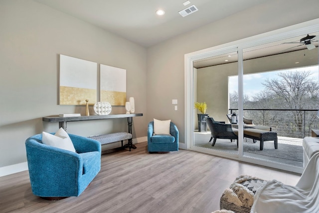 living area featuring ceiling fan and light hardwood / wood-style floors