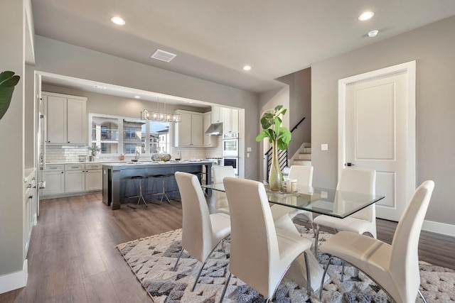 dining area featuring dark hardwood / wood-style floors and a chandelier