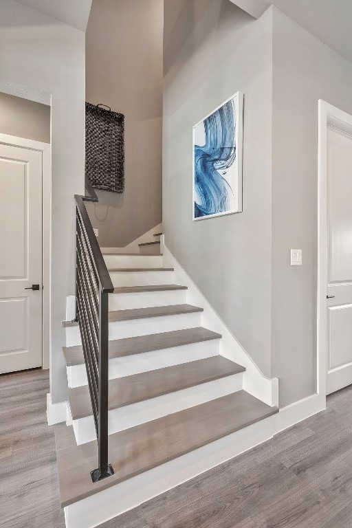 stairway with light hardwood / wood-style floors