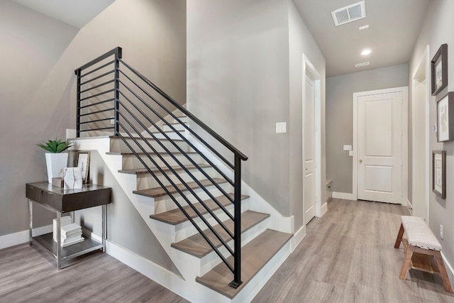 stairway with light hardwood / wood-style floors