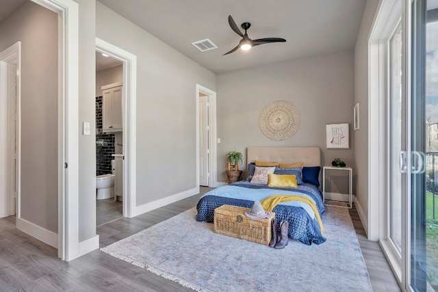 bedroom with multiple windows, light hardwood / wood-style floors, ceiling fan, and ensuite bathroom