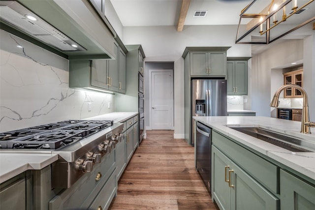 kitchen featuring backsplash, custom exhaust hood, beamed ceiling, and hardwood / wood-style floors