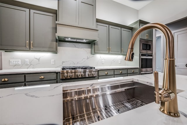 kitchen with light stone counters, backsplash, custom exhaust hood, and stainless steel appliances