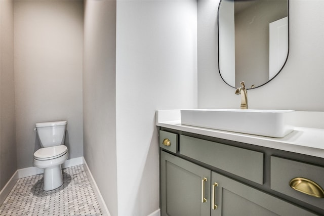 bathroom featuring tile flooring, vanity, and toilet