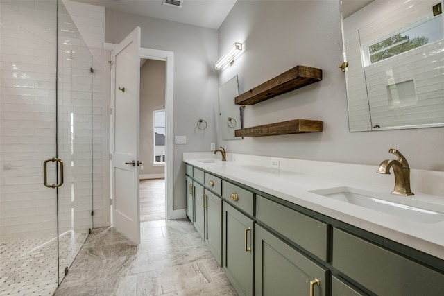 bathroom featuring a shower with door, tile floors, and double sink vanity