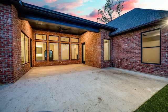 back house at dusk featuring a patio