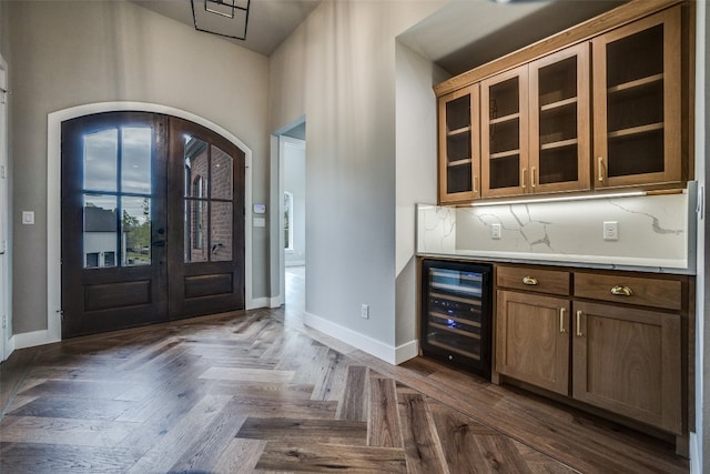 entrance foyer with wine cooler, french doors, and dark parquet flooring