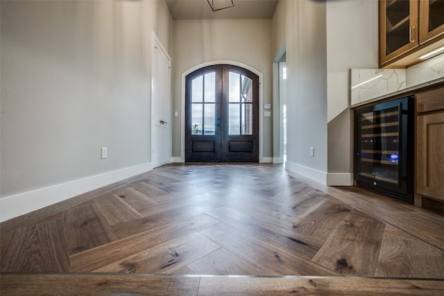 entryway featuring parquet flooring, beverage cooler, french doors, and a high ceiling