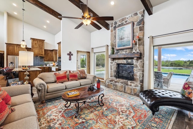 812 Mckenzie Rd, Tioga, TX 76271 - living area with high vaulted ceiling, ceiling fan, a fireplace, wood finished floors, and beam ceiling
