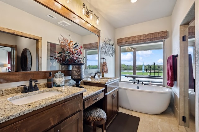 bathroom with tile floors, vanity, and a bathing tub