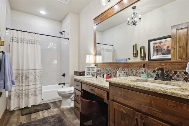 full bathroom with shower / bath combo, toilet, double vanity, wood-type flooring, and an inviting chandelier