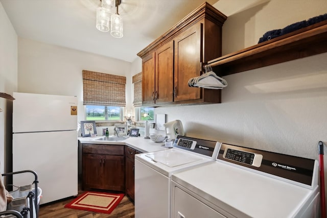 washroom featuring cabinets, dark hardwood / wood-style floors, independent washer and dryer, and sink