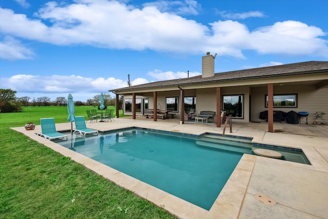 view of swimming pool with a lawn, a patio area, and a jacuzzi