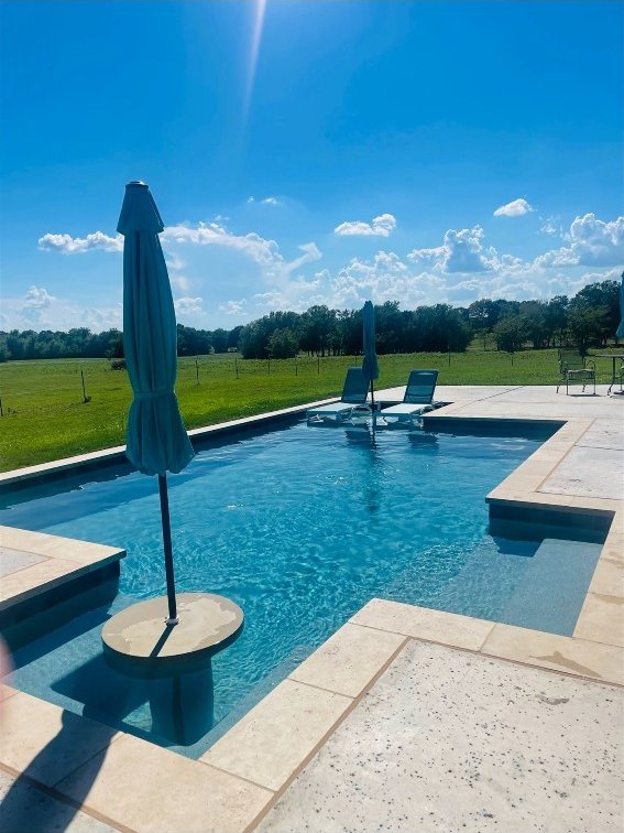 view of pool with a patio and a yard